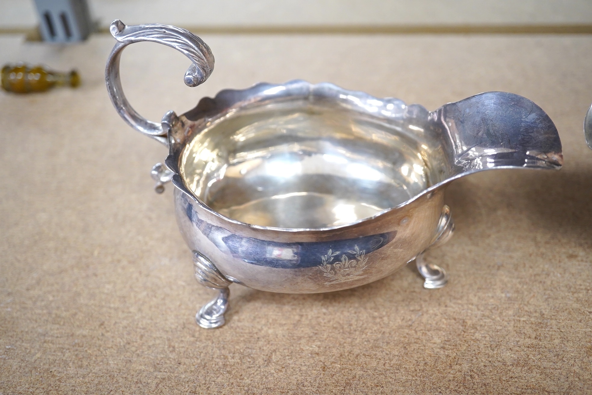 A George II silver sauce boat, London, 1746?, (repair), together with a George V silver sauceboat by Elkington & Co, Birmingham, 1914, 10.5oz. Condition - poor to fair